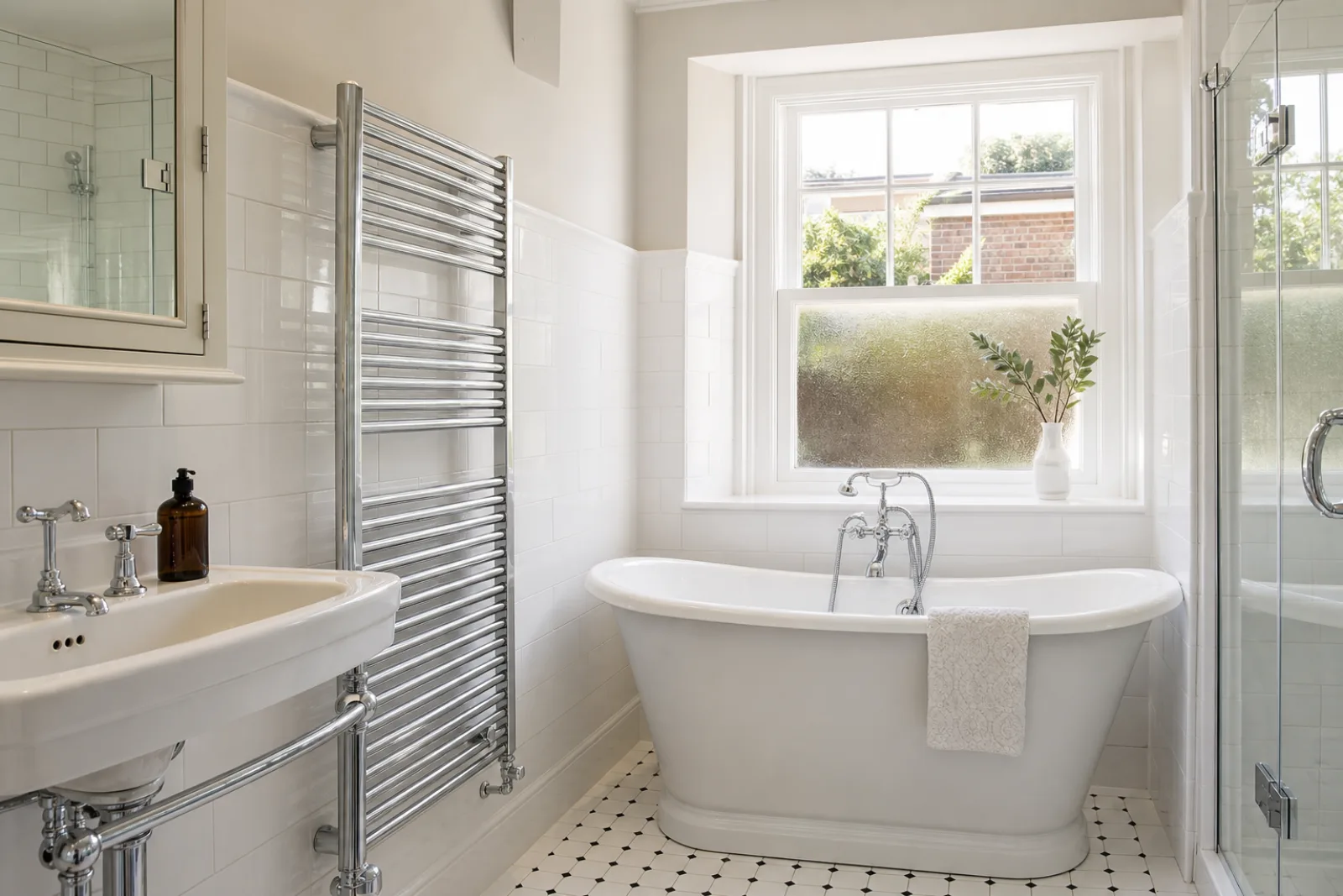 A pristine bathroom with white metro tiles and a gleaming chrome towel radiator in a British Edwardian semi-detached house just after a professional clean