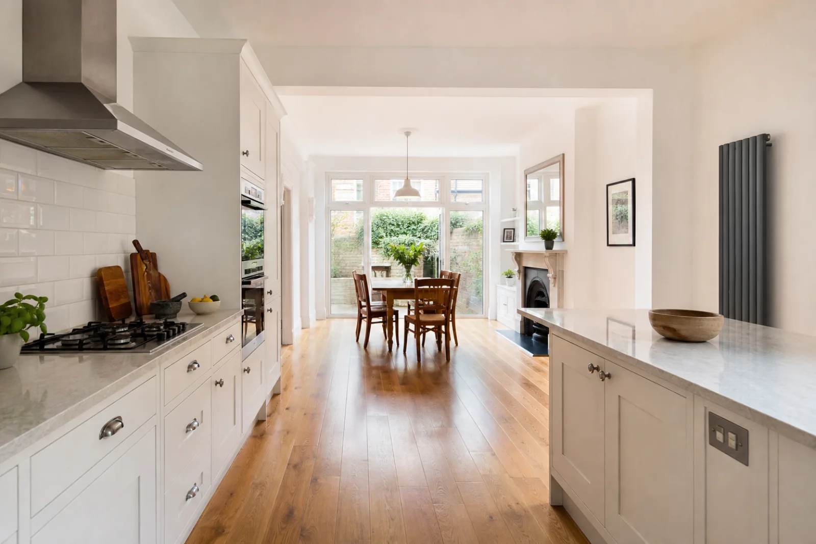 A freshly cleaned, spotless open-plan kitchen diner with oak flooring in a British Victorian terraced house, bright overcast daylight, everything gleaming and p