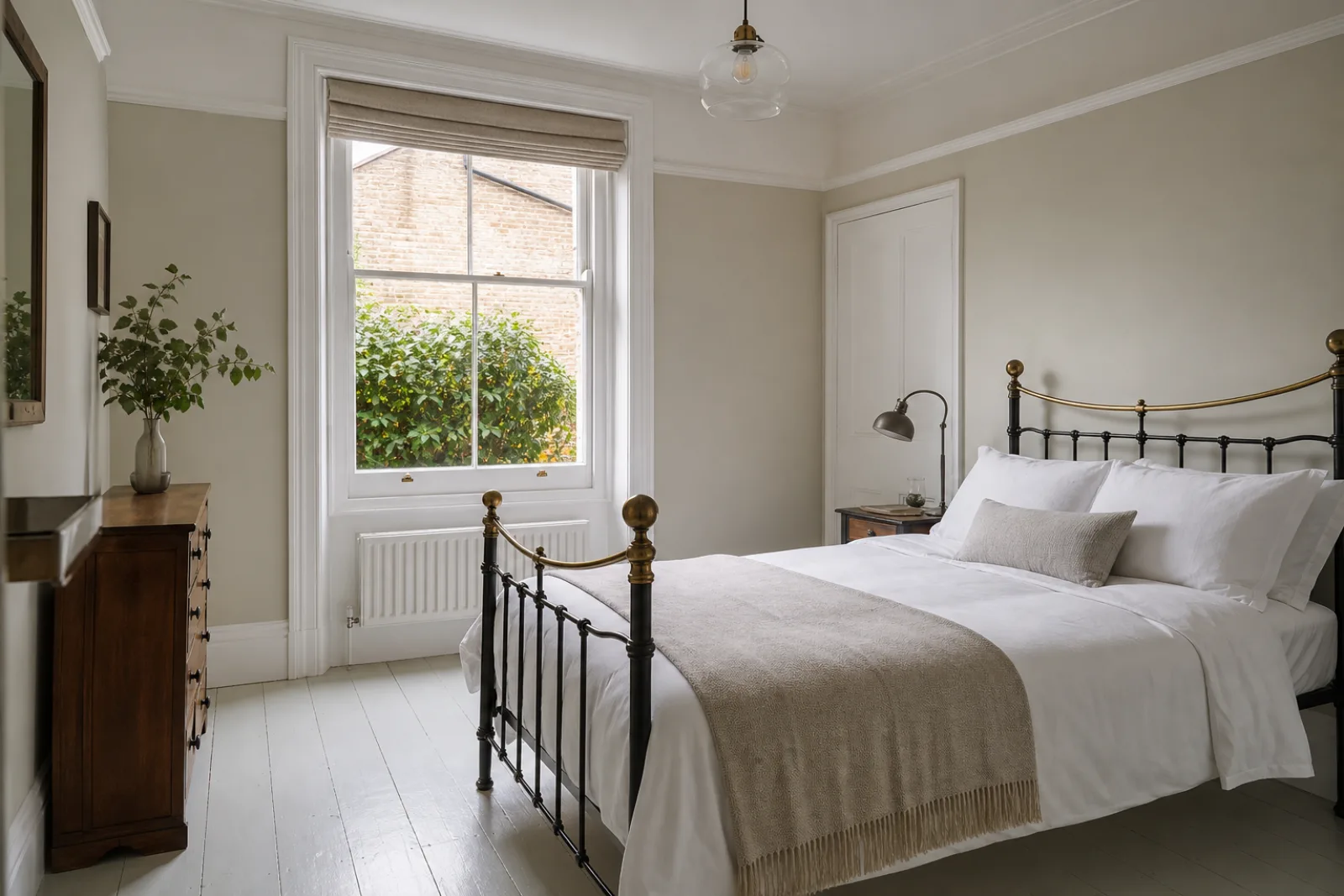 A freshly cleaned, spotless bedroom with painted floorboards and a neatly made bed in a British Victorian terraced house