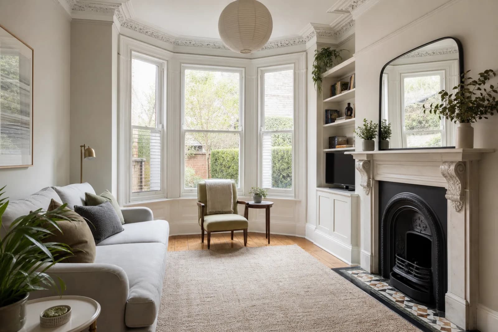 A pristine living room with a bay window and period fireplace in a British Victorian terraced house just after a professional clean, bright overcast daylight, s