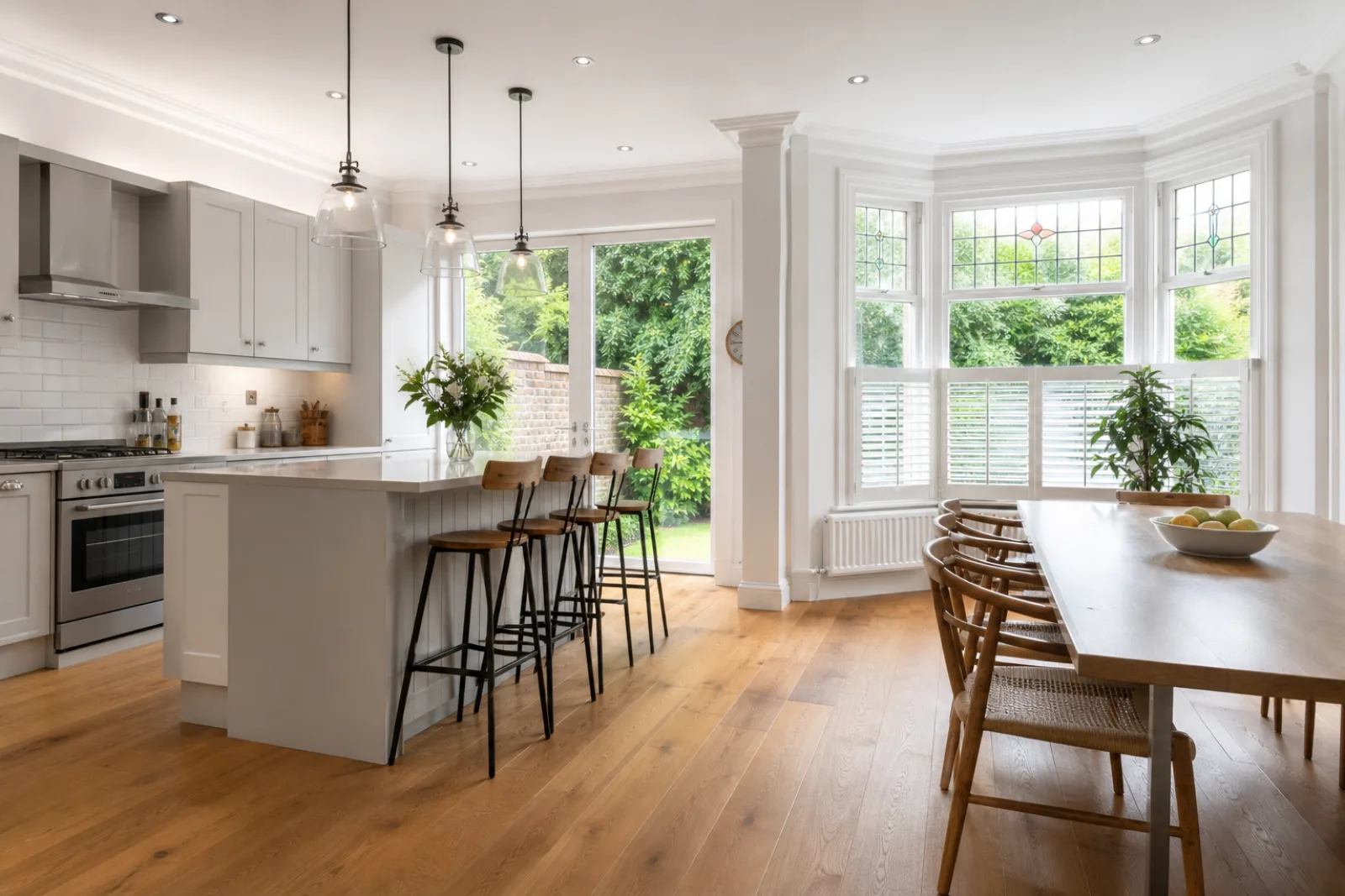 A freshly cleaned, spotless open-plan kitchen diner with oak flooring in a British Edwardian semi-detached house, bright overcast daylight, everything gleaming 