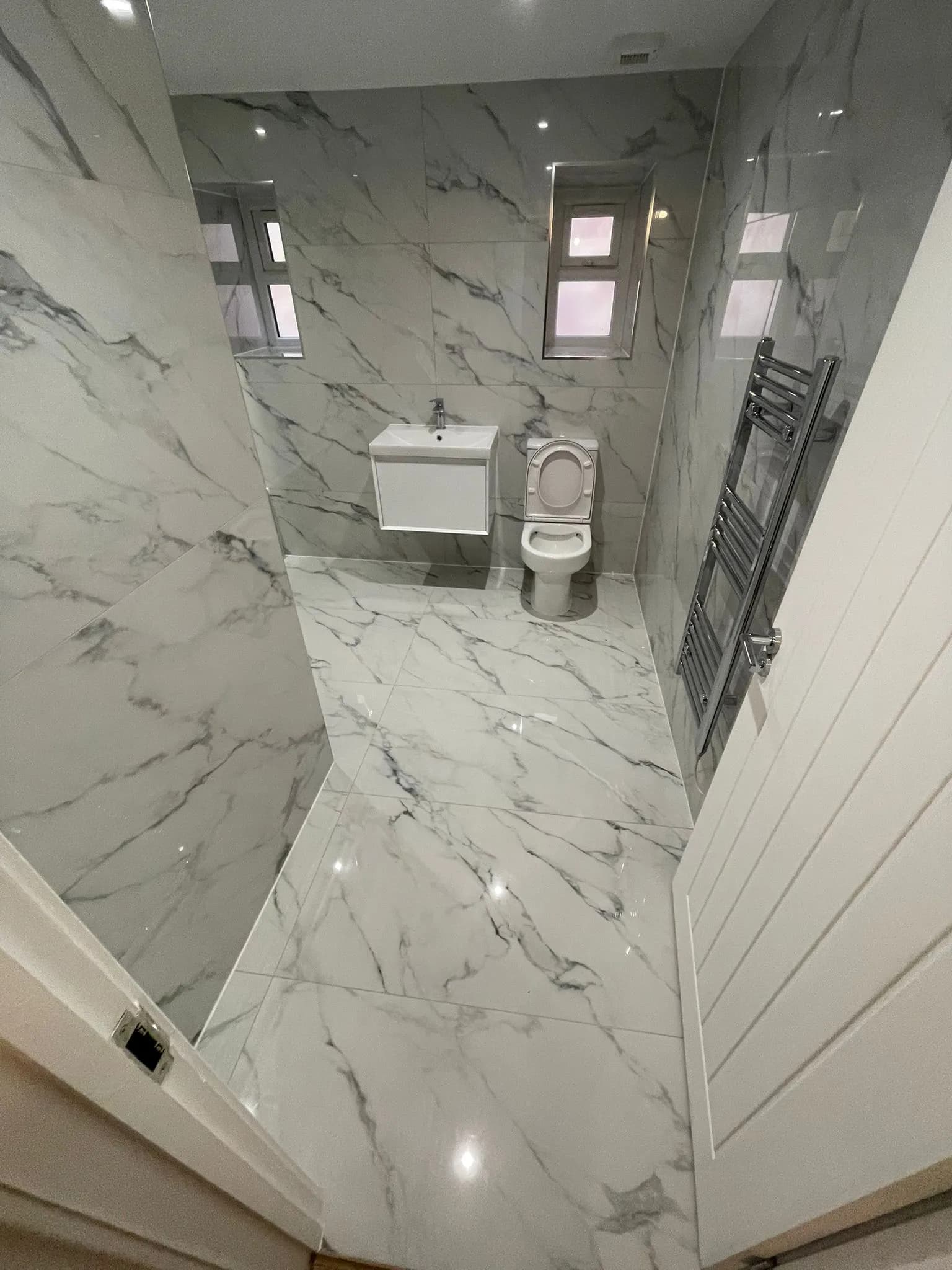 Marble-tiled bathroom and towel radiator after a deep clean