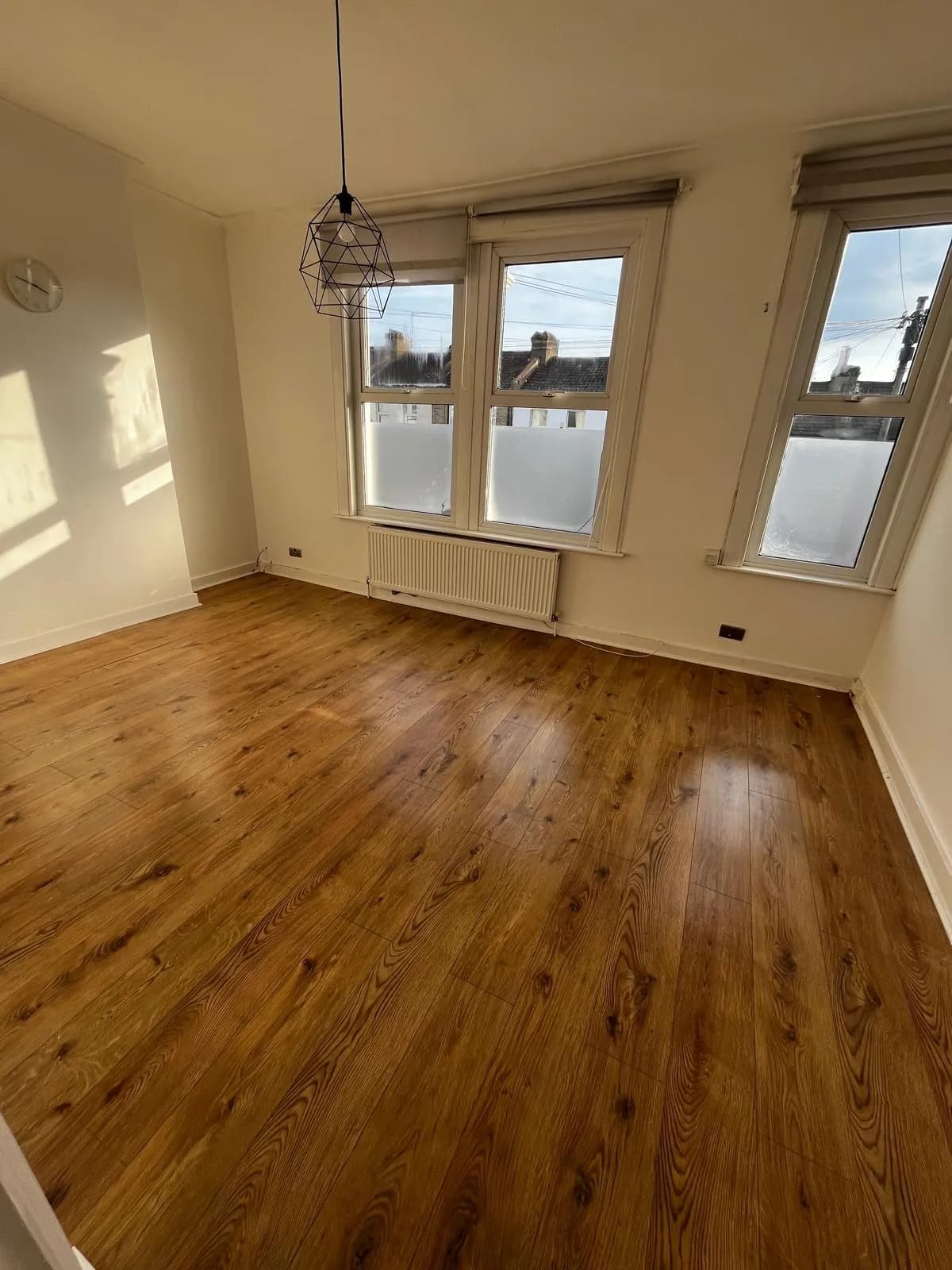 Empty room with polished wooden floor after an end of tenancy clean